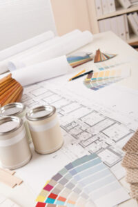 drafting table with blueprints, paint swatches and paint cans