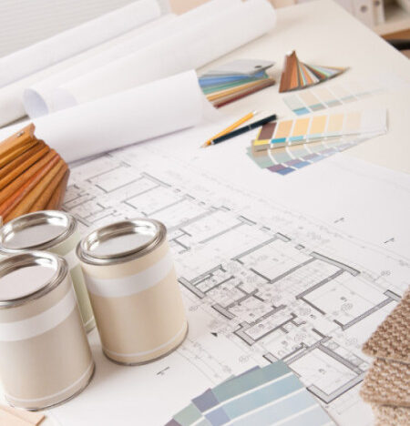 drafting table with blueprints, paint swatches and paint cans